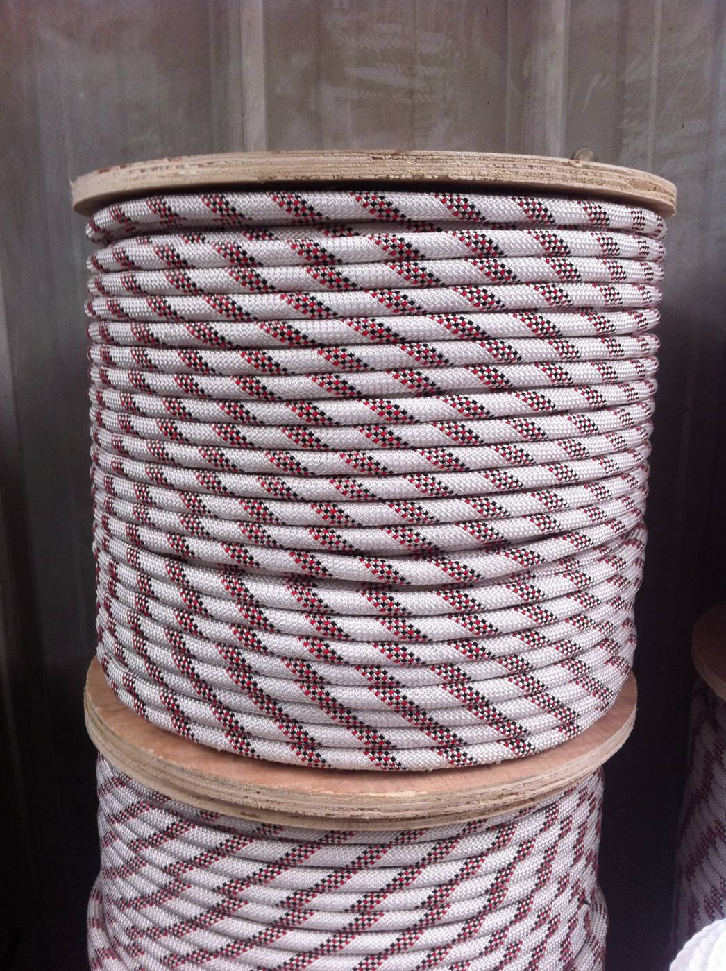 Red and white polypropylene baler twine wound on a wooden drum