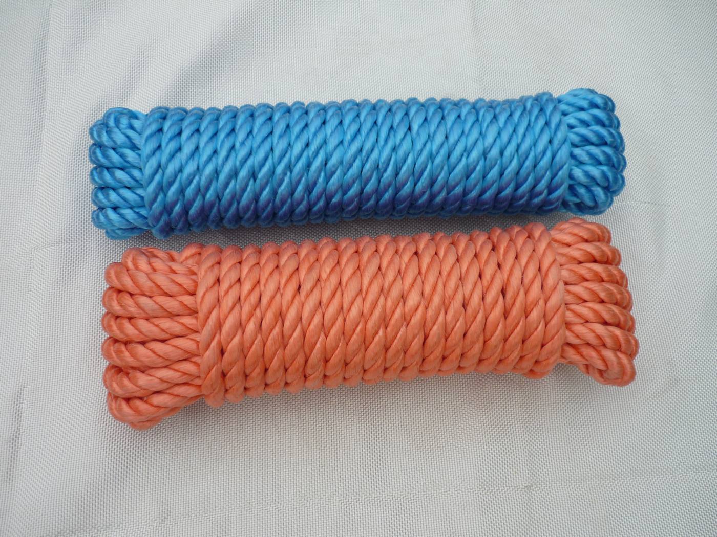 Blue 3-strand twisted rope coil on a small spool, side view